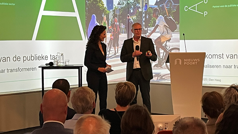 Han Busker op het podium in Nieuwspoort, in gesprek met dagvoorzitter Yasmin Ait Abderrahman