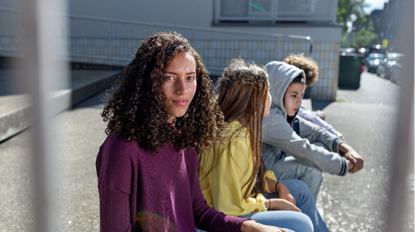 Vier jongeren zitten naast elkaar op een bankje